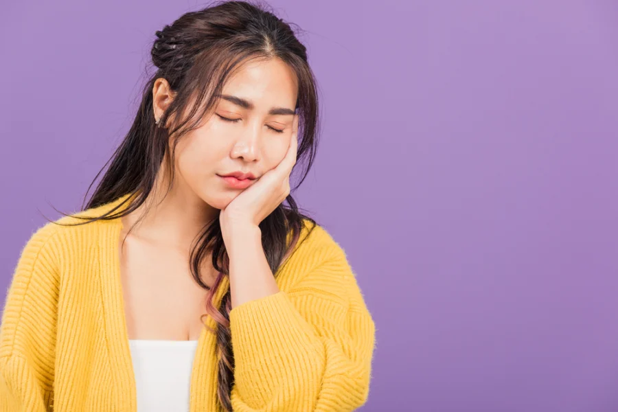 Young woman with jaw pain, illustrating how braces fix jaw alignment issues.