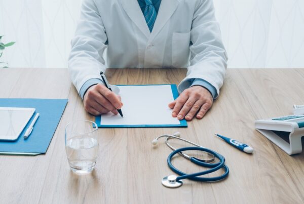 Orthodontist reviewing paperwork at desk discussing flexible payment plans for affordable orthodontics treatment in Raleigh