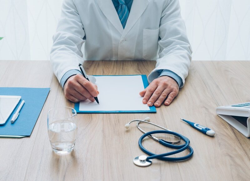 Orthodontist reviewing paperwork at desk discussing flexible payment plans for affordable orthodontics treatment in Raleigh